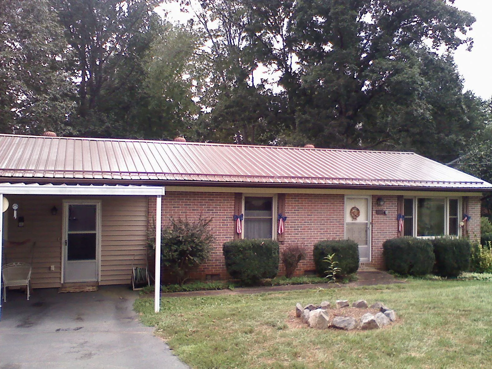 Bronze metal roof and carport on a brick ranch home — Roof Repair work by our crew in Bushwood