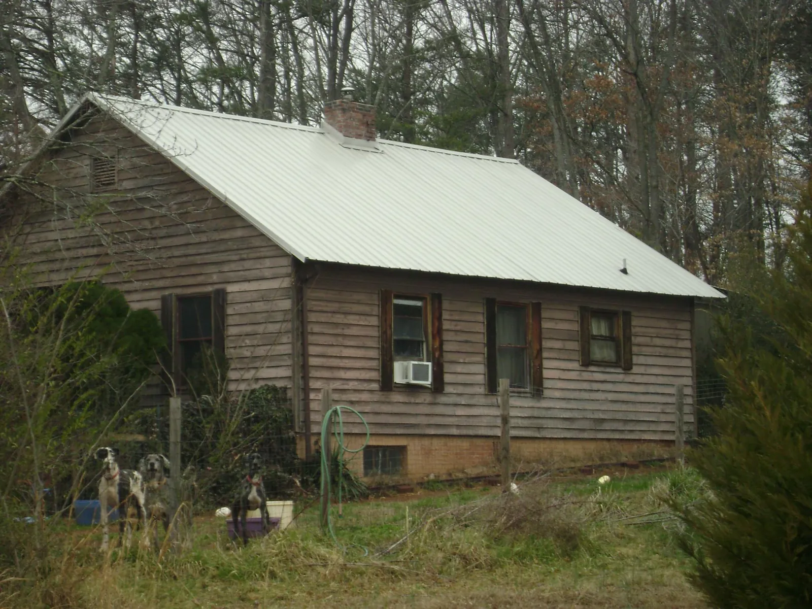 White metal roof on an old wood sided farmhouse, from a Metal Roof Installation job in Bushwood